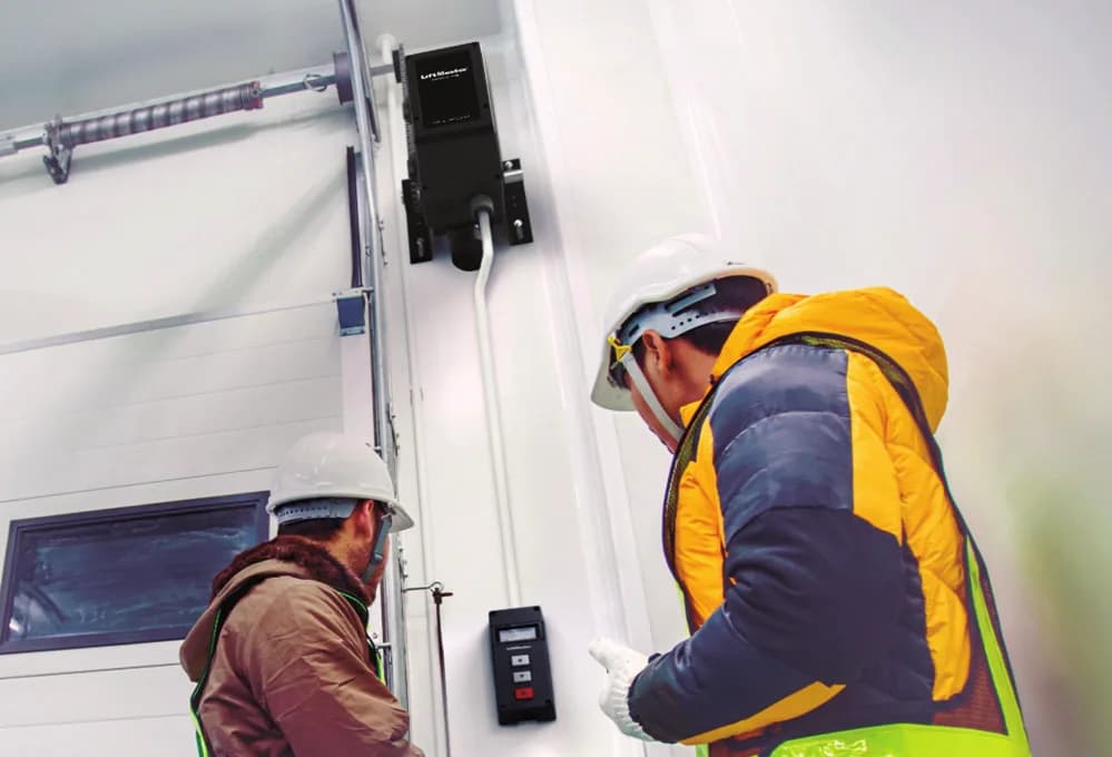 LiftMaster MAXUM JDC operator and wall controller being installed beside a commercial sectional door