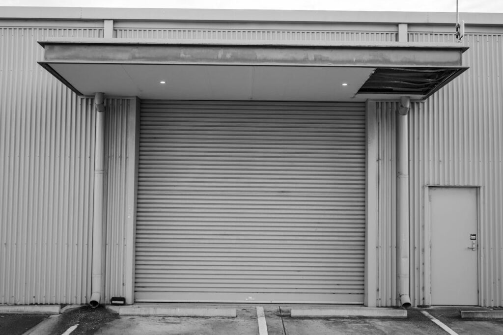 Black and white image of a closed industrial garage door with corrugated metal exterior Vancouver BC